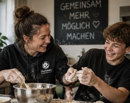 Pädagogin und Jugendlicher backen gemeinsam in der Küche
